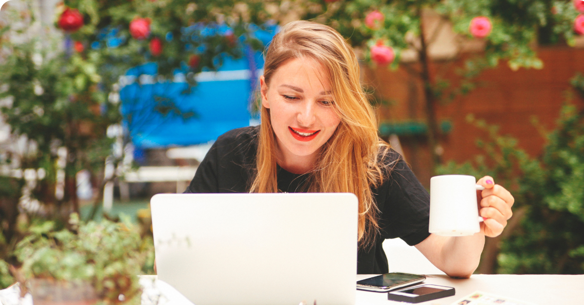 Lady Holding Coffee on Laptop